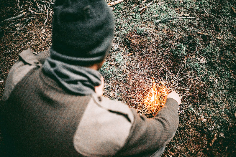 Man lighting a fire in the woods