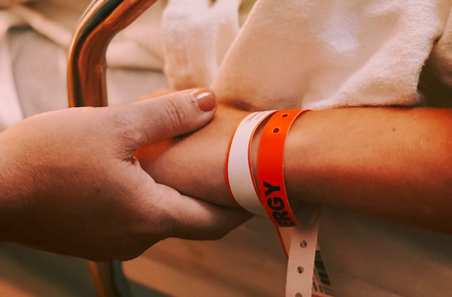 Person wearing orange and white silicone band