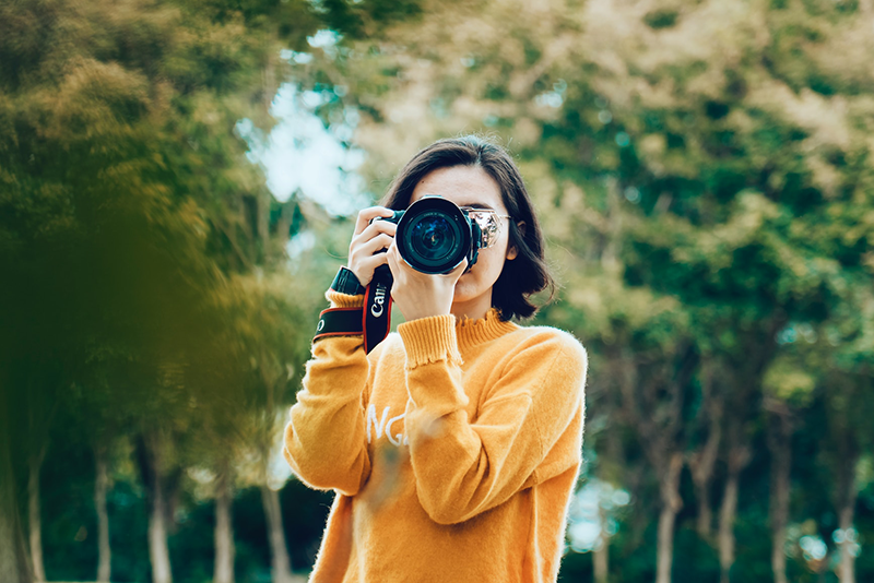 Woman holding a camera in nature