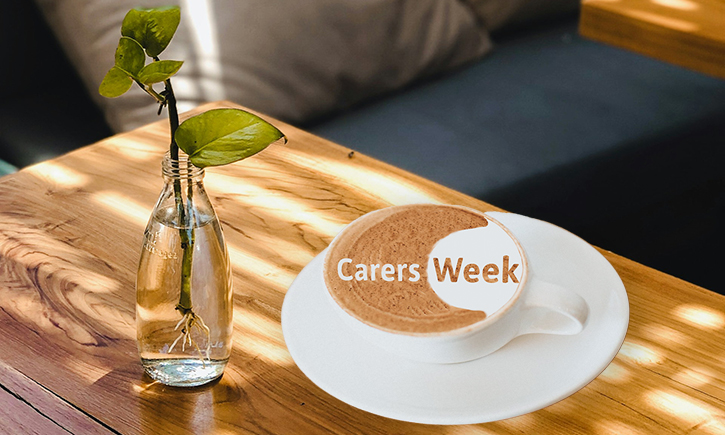 Coffee on a table with Carers Week logo in the froth