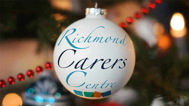 A Christmas bauble with Richmond Carers Centre written on it in calligraphy