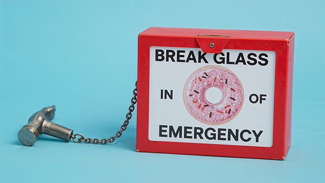 Break Glass in Case of Emergency. Image shows an emergency box with a doughnut on the front. A humorous take on a 'reboot' box filled with small comforts. 