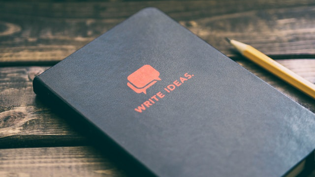 Write Ideas notebook on brown wooden board