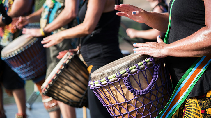 Photo of a row of drummers beating African drums