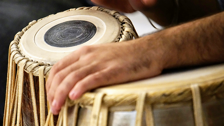 Kirtan activity. Image shows a pair of Indian tabla (drums) with a hand resting on one of the drums