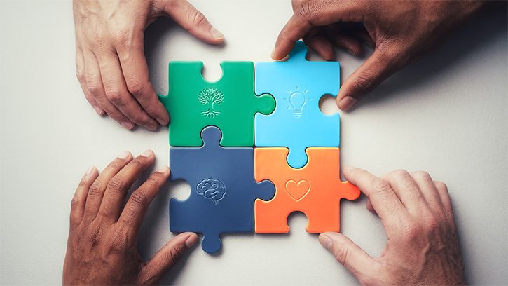 Four hands putting a four-piece puzzle together. The puzzle pieces are in Richmond Carers Centre brand colours