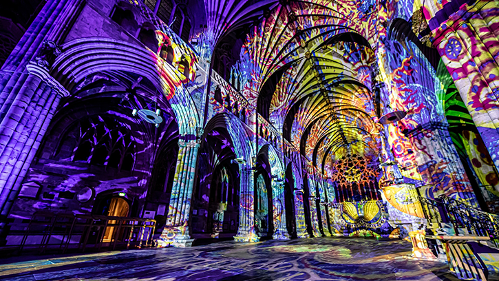 The sculpted interior of the Landmark Arts Center, illuminated by a physchadelic light show of purples, yellows and greens