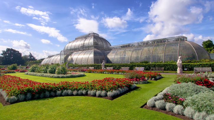 Kew Gardens main greenhouse glistening in the sun on a luscious green lawn.
