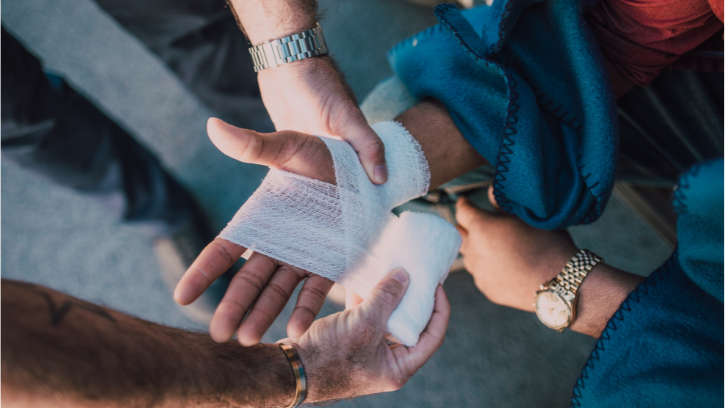 Carer practicing wrists and hand sprain wrapping on a fellow carer